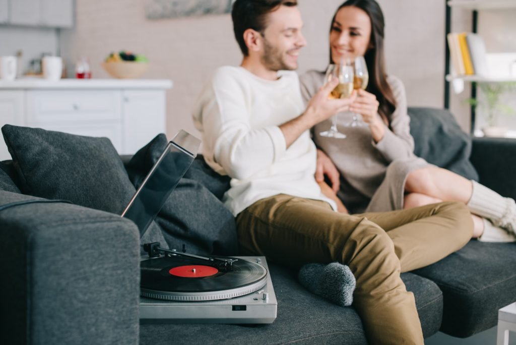 La música y el vino: 6 canciones con vino 1 happy young couple listening music with vinyl reco TAUYMM6 scaled 1