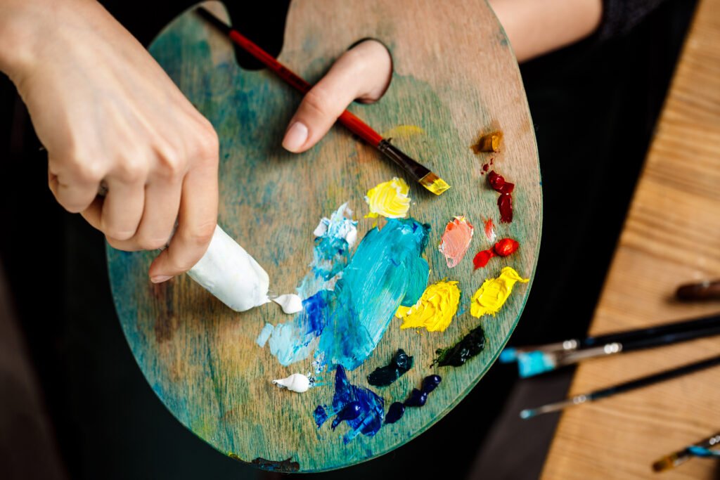 cerca de mujer exprimiendo pintura de aceite blanco en la paleta