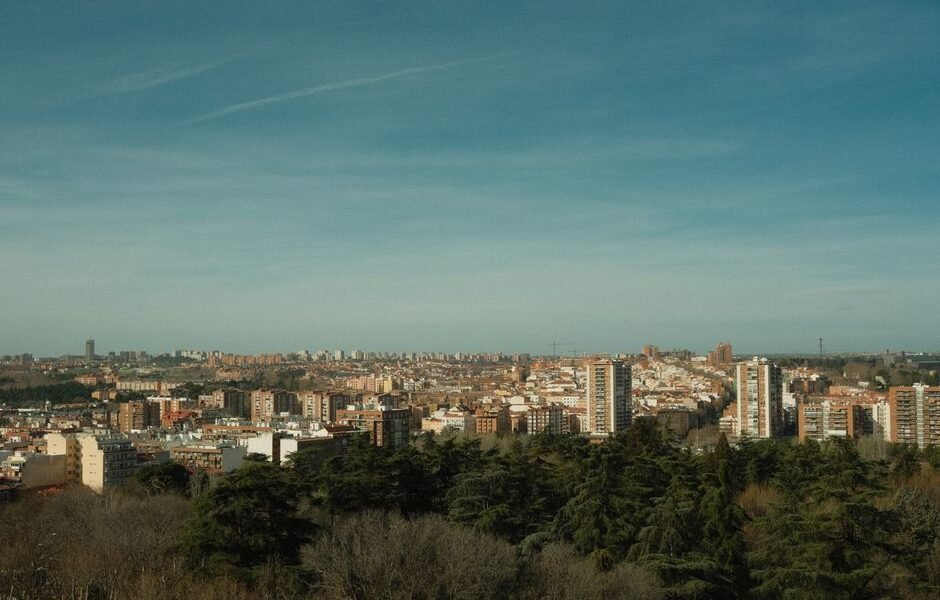 Una amplia vista del horizonte de Madrid bajo un cielo azul claro, rodeado de arquitectura urbana y vegetación.