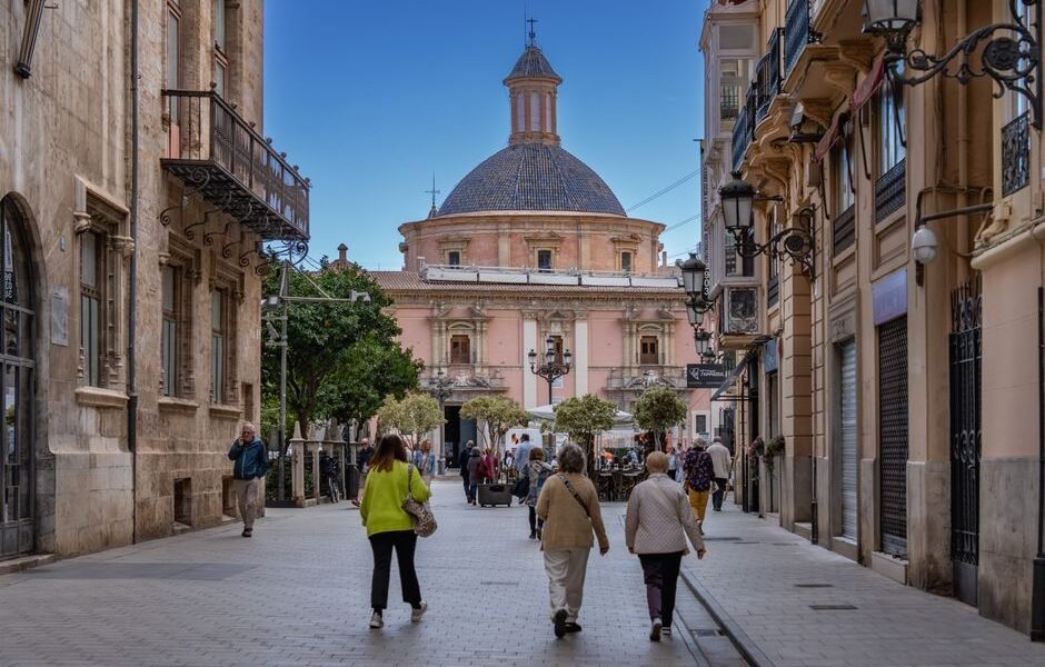 Encantadora calle en Valencia con arquitectura histórica y personas disfrutando del día.