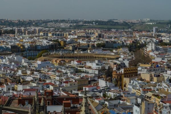 Una impresionante vista aérea de Sevilla que muestra la icónica plaza de toros y la arquitectura histórica circundante.