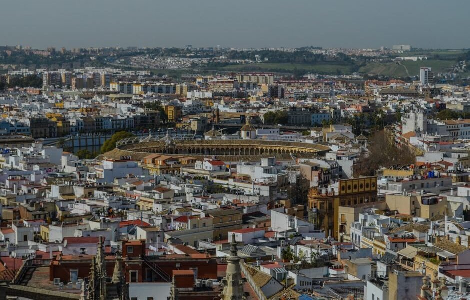 Una impresionante vista aérea de Sevilla que muestra la icónica plaza de toros y la arquitectura histórica circundante.